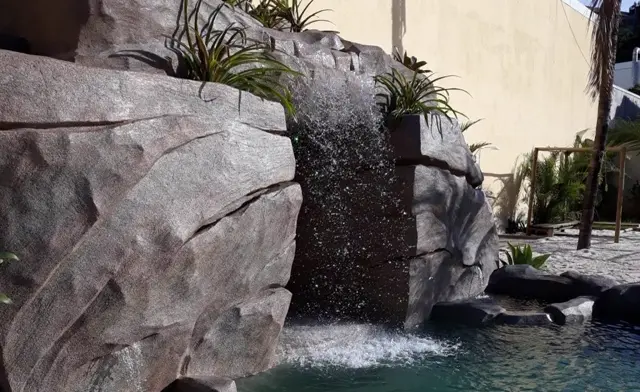 Cascata de pedra artificial com queda de água em piscina
